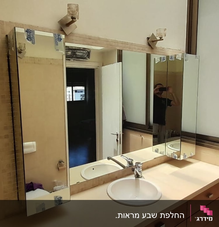 מראה גדולה עם מסגרת מתכת בחדר אמבטיה